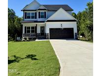 Charming two-story home featuring a well-manicured lawn, a two car garage, and stone accents at 60 Moonraker Dr, Spring Hope, NC 27882