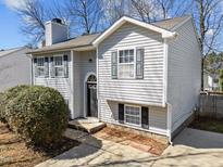 Charming two-story home with gray siding, black shutters, arched entryway, and well-manicured landscaping at 608 Oleander Rd, Raleigh, NC 27603
