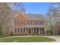 Beautiful two-story brick home featuring a manicured lawn and classic architectural details at 6116 Wilkinsburg Rd, Raleigh, NC 27612