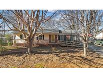 Charming single-story home with a wooden porch, brick accents, and a convenient access ramp at 639 Woodhaven Dr, Burlington, NC 27217