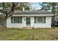 Charming one-story home with white brick, green shutters, and mature trees at 740 Long Ave, Rocky Mount, NC 27801
