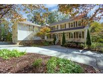Charming home with a covered front porch, beautiful landscaping, and a long drive at 10004 Liana Ln, Raleigh, NC 27613