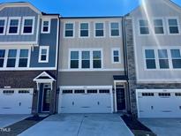 New townhomes featuring varying colors, multi-car garages, and craftsman-style front doors at 10016 Secluded Garden Drive Rd # 186, Apex, NC 27523