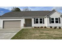 Charming single-story home with a manicured lawn, attached garage, and neutral color scheme at 103 Oakfield Trace Dr, Four Oaks, NC 27524