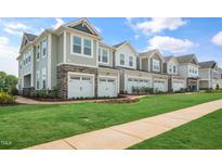 Row of newly-constructed townhomes featuring attached garages and professionally manicured landscaping at 104 Siebold St, Garner, NC 27529