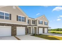 Charming townhouse with a two-car garage, stone accents, and manicured landscaping at 279 Canopy Dr, Graham, NC 27253