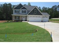 Charming two-story home features a three-car garage and a well-manicured lawn at 358 Coats Ridge Dr, Benson, NC 27504