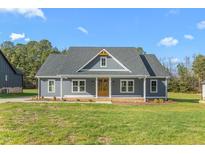 Charming single-story home with a blue exterior, covered porch, and well-manicured lawn at 4037 Mebane Oaks Rd, Mebane, NC 27302