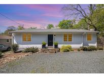 Charming single-story home featuring a gravel yard, stone steps, and inviting front entrance at 424 S Greensboro St, Carrboro, NC 27510