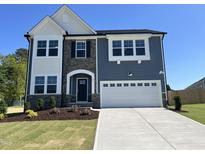 Charming two-story home with a stone facade, white trim, and a two-car garage at 46 Shortstop Cir, Four Oaks, NC 27524