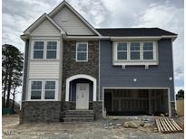 New two-story home featuring a stone facade, a covered entryway, and an attached two-car garage at 46 Shortstop Cir, Four Oaks, NC 27524