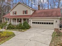 Charming two-story home featuring a covered porch, attached garage and a well-maintained lawn and landscaping at 5012 Springwood Dr, Raleigh, NC 27613