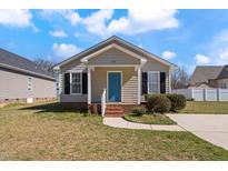 Charming single-story home with a bright blue front door and manicured lawn at 615 S Orange Ave, Dunn, NC 28334