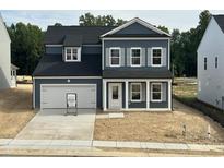 Two story home featuring blue siding, white trim, black roof, and an attached two car garage at 704 Compeer Way # 28, Rolesville, NC 27571