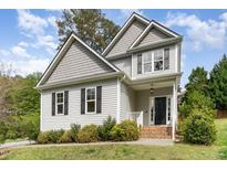 Charming two-story home with gray siding, black shutters, and a neatly landscaped front yard at 101 Lager Ln, Garner, NC 27529