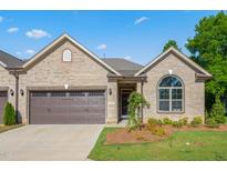 Inviting brick home featuring an attached garage and a manicured lawn at 1053 Beechcraft Dr # 124, Mebane, NC 27302