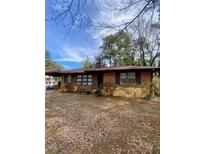 Charming brick home with a covered front porch and mature landscaping, offering a classic appeal at 1115 Park Ave, Henderson, NC 27536