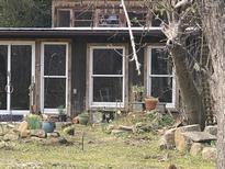 Charming exterior with rustic wood and large windows, enhanced by a natural landscaped garden at 1509 Smith Level Rd, Chapel Hill, NC 27516