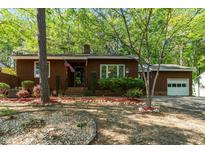 Charming single-story home featuring a well-manicured front yard with mature trees and garden beds at 1801 Irish Blvd, Sanford, NC 27332