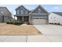 Beautiful two-story home featuring a two-car garage, manicured lawn, and covered porch for relaxing outside at 1916 Edens Ridge Ave, Wake Forest, NC 27587