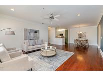 Bright, open-concept living room with hardwood floors, neutral decor, and ample natural light showcases refined comfort at 201 Finsbury St # 201, Durham, NC 27703