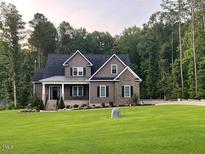 Traditional home featuring a covered front porch and a large grassy yard at 442 Hunters Pointe Rd, Nashville, NC 27856