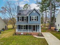 Charming two-story home with blue siding, front porch, and solar panels at 4941 Royal Adelaide Way, Raleigh, NC 27604