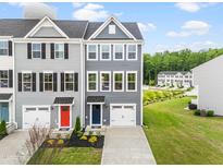 New two-story townhomes showcase modern gray siding, individual garages, and colorful front door accents at 611 Silverado Sunset Loop, Wendell, NC 27591