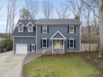 Charming two-story home with blue siding, black shutters, and a bright yellow front door at 8304 Circlewood Ct, Raleigh, NC 27615