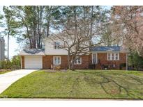 Charming two-story brick home with well-maintained lawn and attached garage at 1004 Plateau Ln, Raleigh, NC 27615