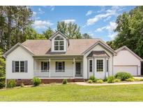 Charming one-story home with a front porch, manicured lawn, and well-maintained landscaping at 1012 Mountain Laurel Dr, Raleigh, NC 27603