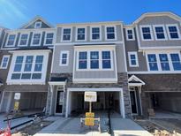 A view of a new construction townhouse exterior with gray paint and stone accents above garage at 1202 Alston Landing Way # 06, Cary, NC 27519