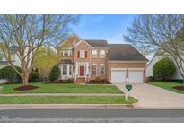 Charming brick two-story home with a well-manicured lawn and two-car garage at 1210 Caribou Xing, Durham, NC 27713