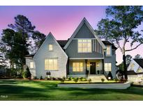 Stunning two-story home with a manicured lawn and classic architectural details during twilight at 2829 Theresa Eileen Way, Raleigh, NC 27603