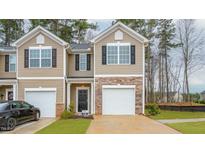 Charming two-story townhome featuring a stone accent, a one car garage and a well-maintained lawn at 2832 Egert Dr, Haw River, NC 27258