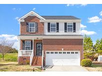 Charming two-story brick and siding home with a two-car garage and manicured lawn at 3007 Cardinal Lake Dr, Durham, NC 27704