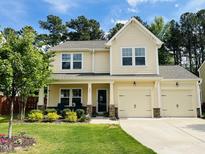Charming two-story home with a well-manicured lawn and inviting front porch at 303 Fortress Dr, Morrisville, NC 27560