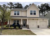 Charming two-story home featuring a two-car garage, landscaped yard, and welcoming front porch at 303 Fortress Dr, Morrisville, NC 27560