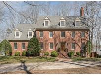 Charming brick home featuring dormer windows, manicured landscaping, and a welcoming front entrance at 4808 Clubview Ct, Fuquay Varina, NC 27526