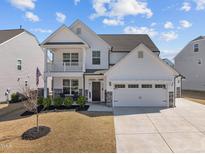 Charming two-story home featuring a covered porch, well-manicured lawn, and an attached two-car garage at 518 Hampton Crest Ct, Fuquay Varina, NC 27526