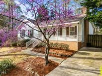 Charming single-story home with a brick foundation, a cozy front porch and a beautiful flowering tree at 5809 Heatherbrook Cir, Raleigh, NC 27612