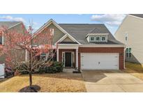 Charming home with well manicured lawn, classic brick, and an attached two-car garage at 717 Maple Brook Rd, Fuquay Varina, NC 27526