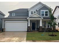 Charming two-story home featuring a two-car garage, a welcoming front porch, and fresh landscaping at 789 Old Station Pointe, Angier, NC 27501