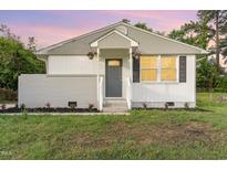 Charming single-story home with a well-manicured front yard and gray front door at 820 Newcombe Rd, Raleigh, NC 27610