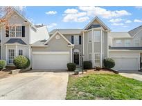 Charming townhouse featuring a garage, manicured lawn, and well-maintained landscaping at 1104 Garnet Ridge Way, Raleigh, NC 27607
