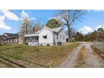 Charming home with a front porch, gravel driveway, and a spacious lawn at 1721 Raleigh Rd, Henderson, NC 27536
