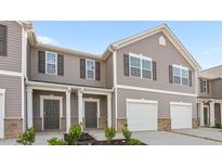 Charming townhome featuring gray siding, white trim, a garage, and a welcoming front porch at 2836 Egert Dr, Haw River, NC 27258