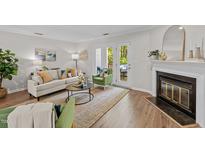Bright living room with fireplace, modern furniture, and outdoor patio access at 3111 Coachmans Way, Durham, NC 27705