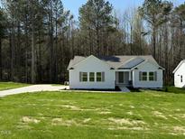 Charming single-story home featuring a well-manicured lawn and a concrete driveway at 325 Magnolia Run Way, Benson, NC 27504