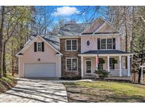 Charming two-story home with a manicured front yard, attached garage, and inviting front porch at 401 Newquay Ln, Wake Forest, NC 27587